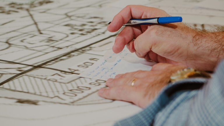Close-up of person sketching architectural drawings