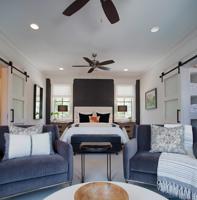 Cozy living room with two blue sofas and a ceiling fan