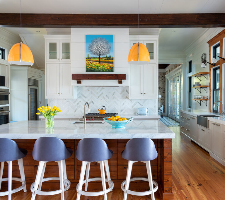 Stylish kitchen with white cabinets, wooden beams, and blue bar stools