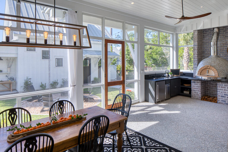 Bright sunroom with large windows, dining table, and outdoor views