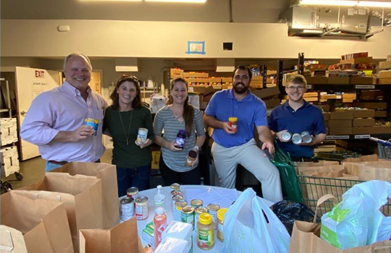The Pearce Scott Architects team posing with food donations inside a storage area.