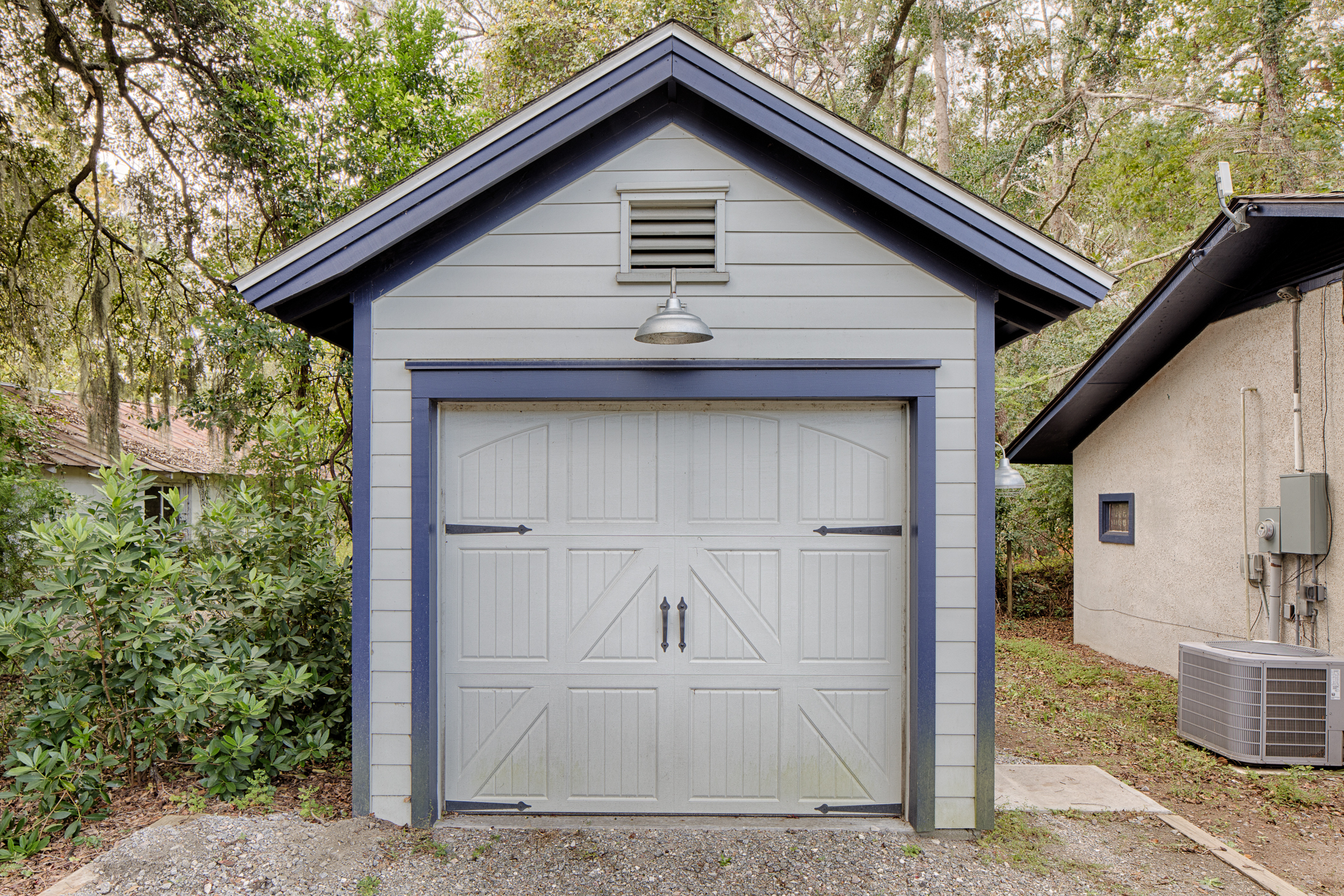 Small detached garage with light gray siding and blue trim.