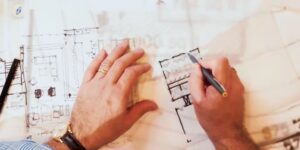 Hand sketching home floorplan on tracing paper.
