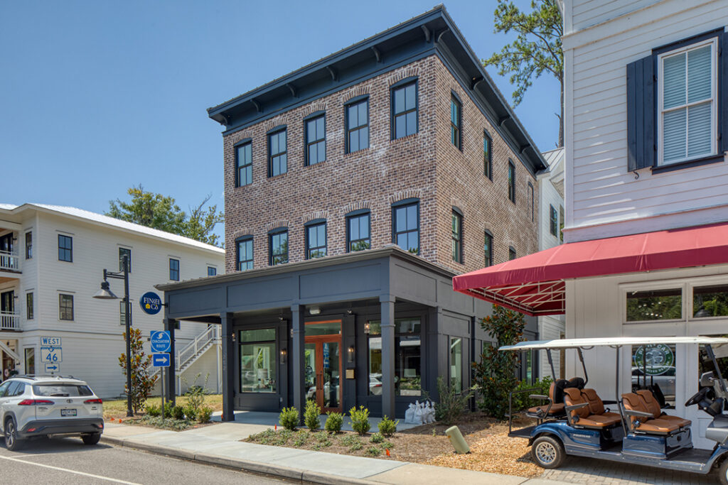 Cottage-style commercial building with picket fence and colorful details.