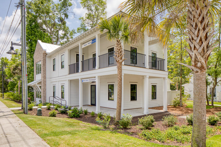 Southern-style building with large porches and palm trees.
