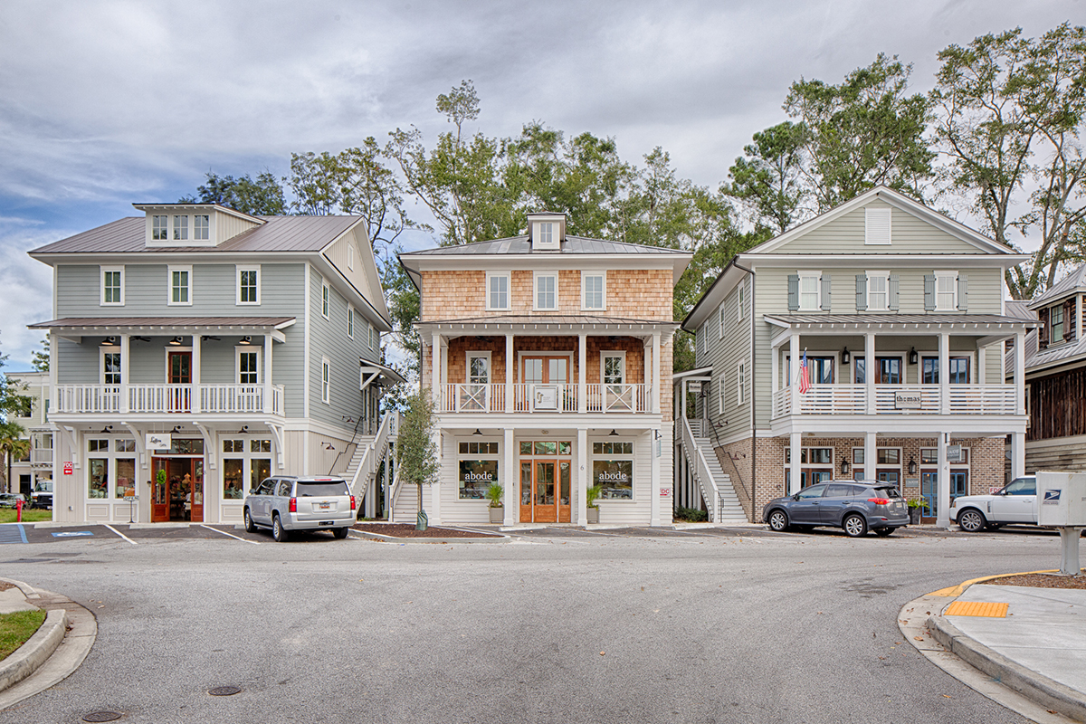 View of multi-use building flanked by residential units on both sides.