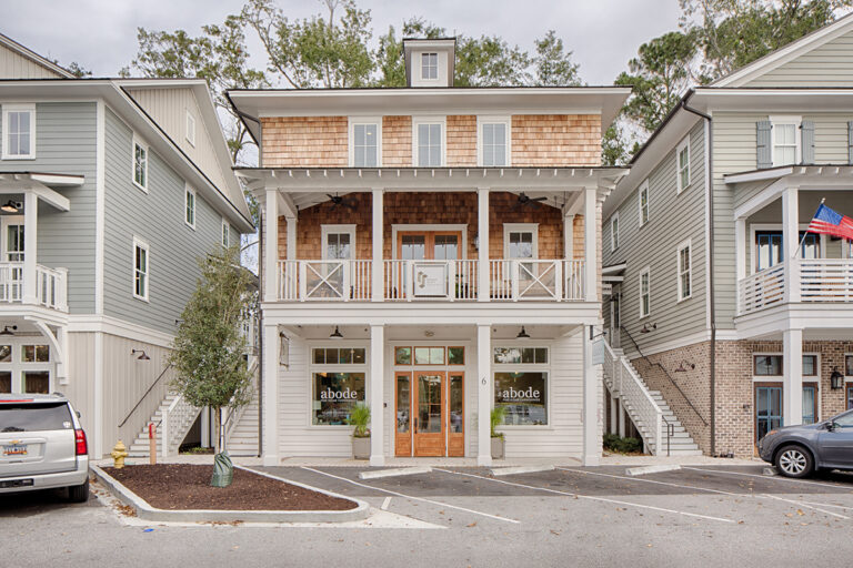 Retail storefront with upper balcony and white façade.