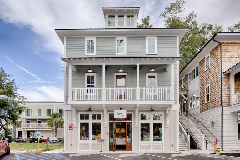 Multi-use development with light gray siding, balconies, and storefronts.