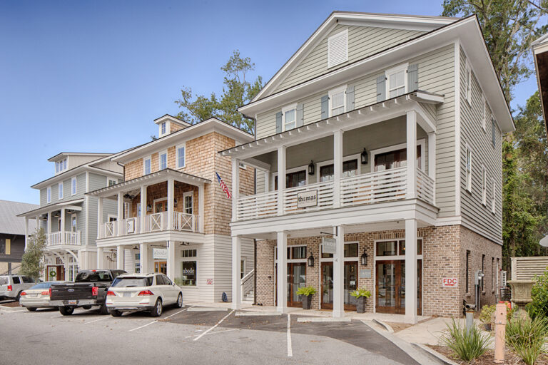 Commercial building with wraparound porches and light neutral palette.
