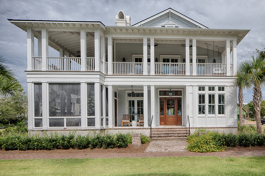 The rear elevation of a classic coastal home with double porches, a central brick staircase, and large screened-in areas for outdoor living.