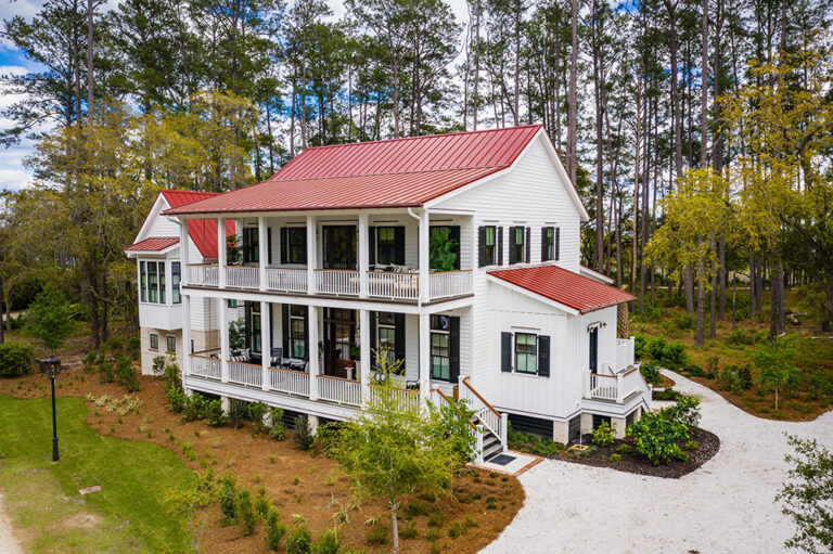 A white Southern-style house surrounded by woods.