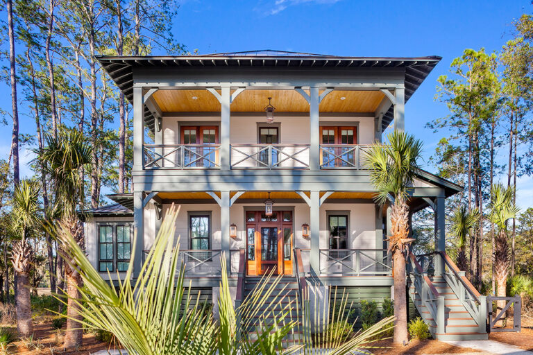 Mediterranean-style home with two-story porches and terra cotta roofing.