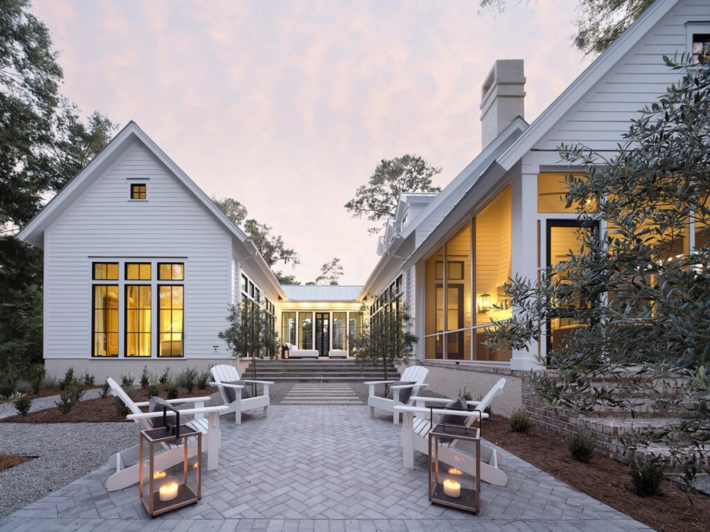 Spacious outdoor courtyard with white furniture and warm lighting.