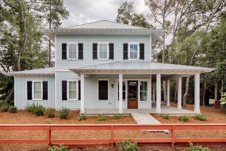 Two-story white historic-style office building with black shutters and a wraparound front porch.